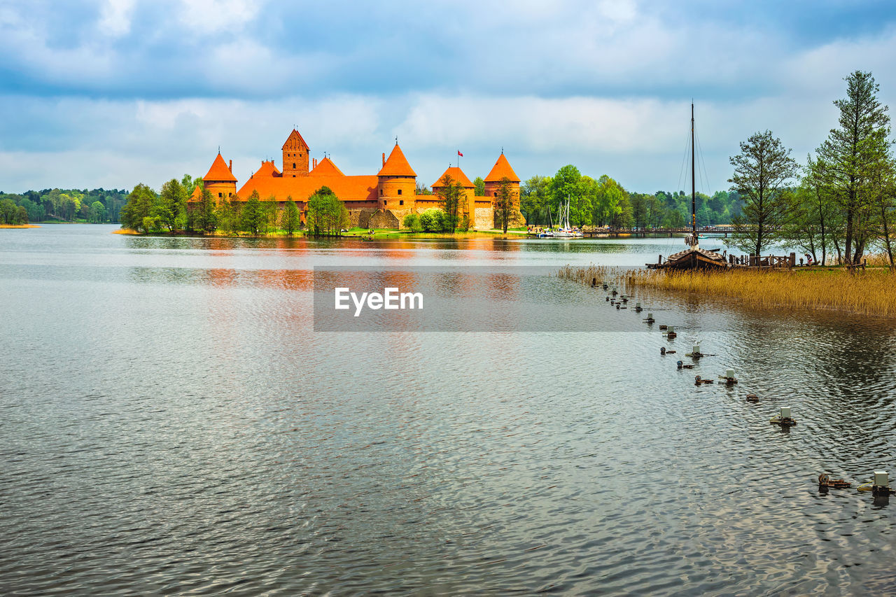 Trakai island castle amidst lake galve against cloudy sky