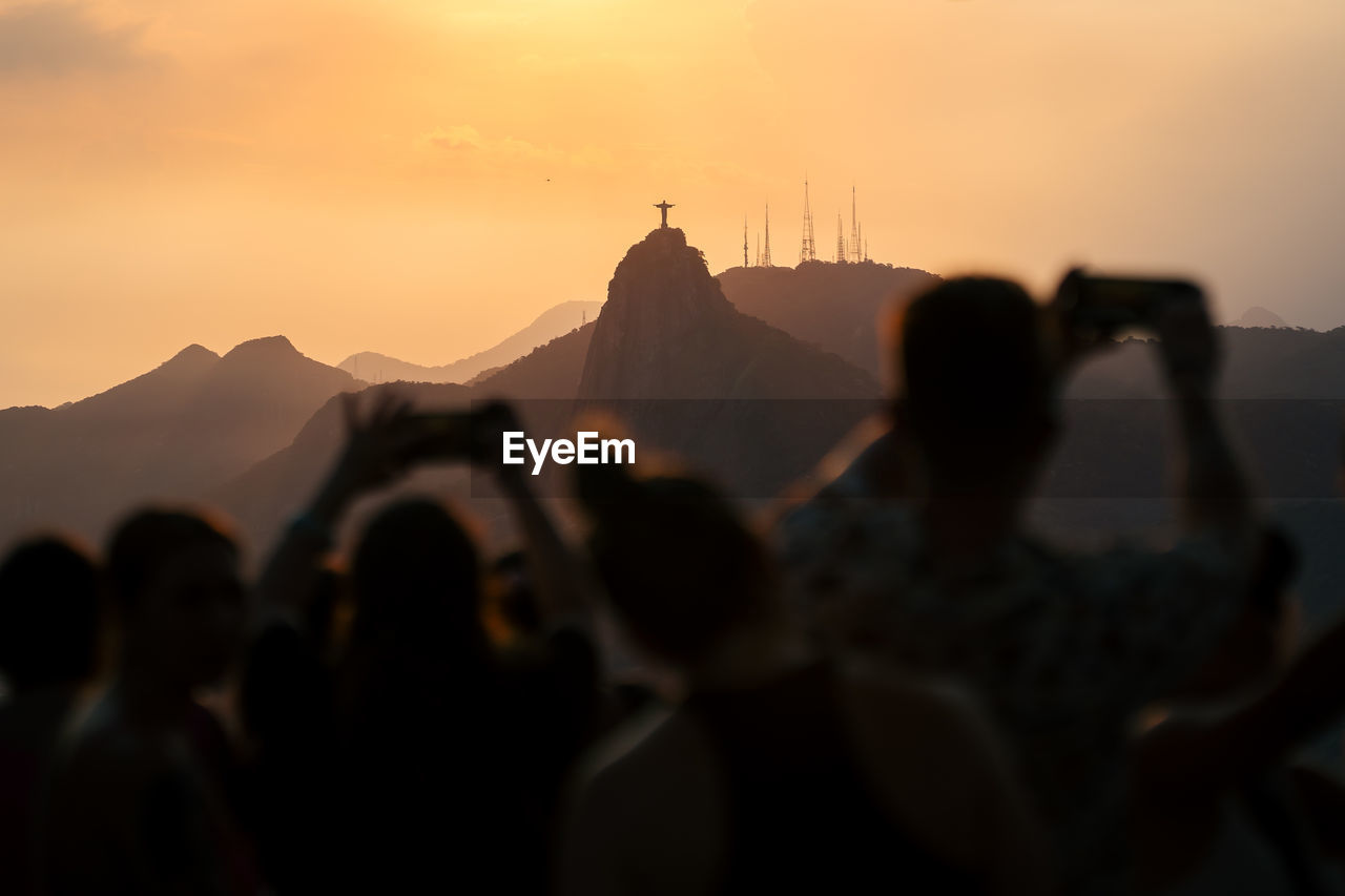 Tourists enjoy the view from the sugarloaf mountain towards the christ the redeemer statue of rio