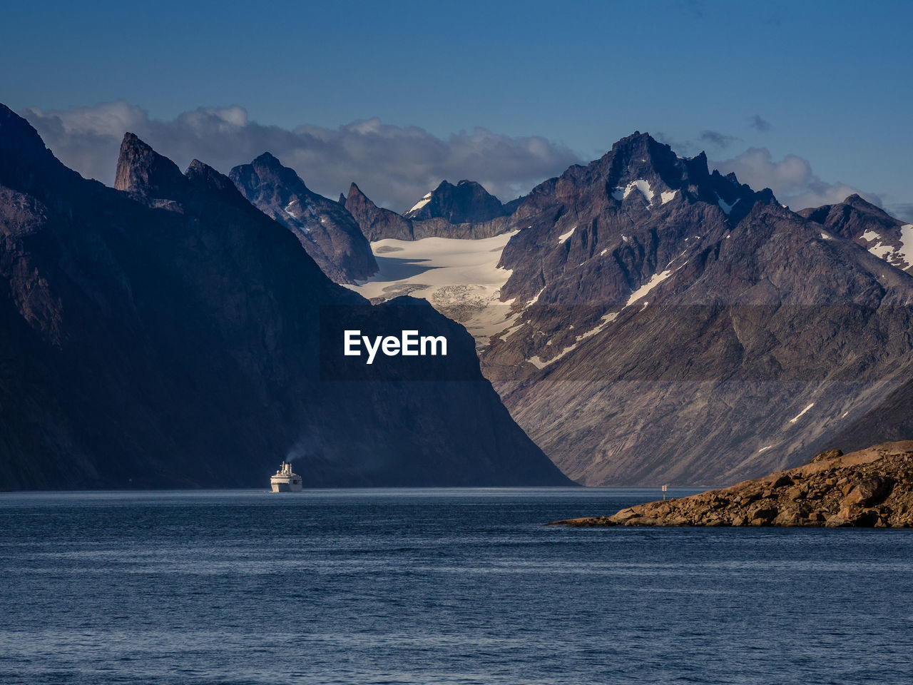 Scenic view of sea and mountains against sky