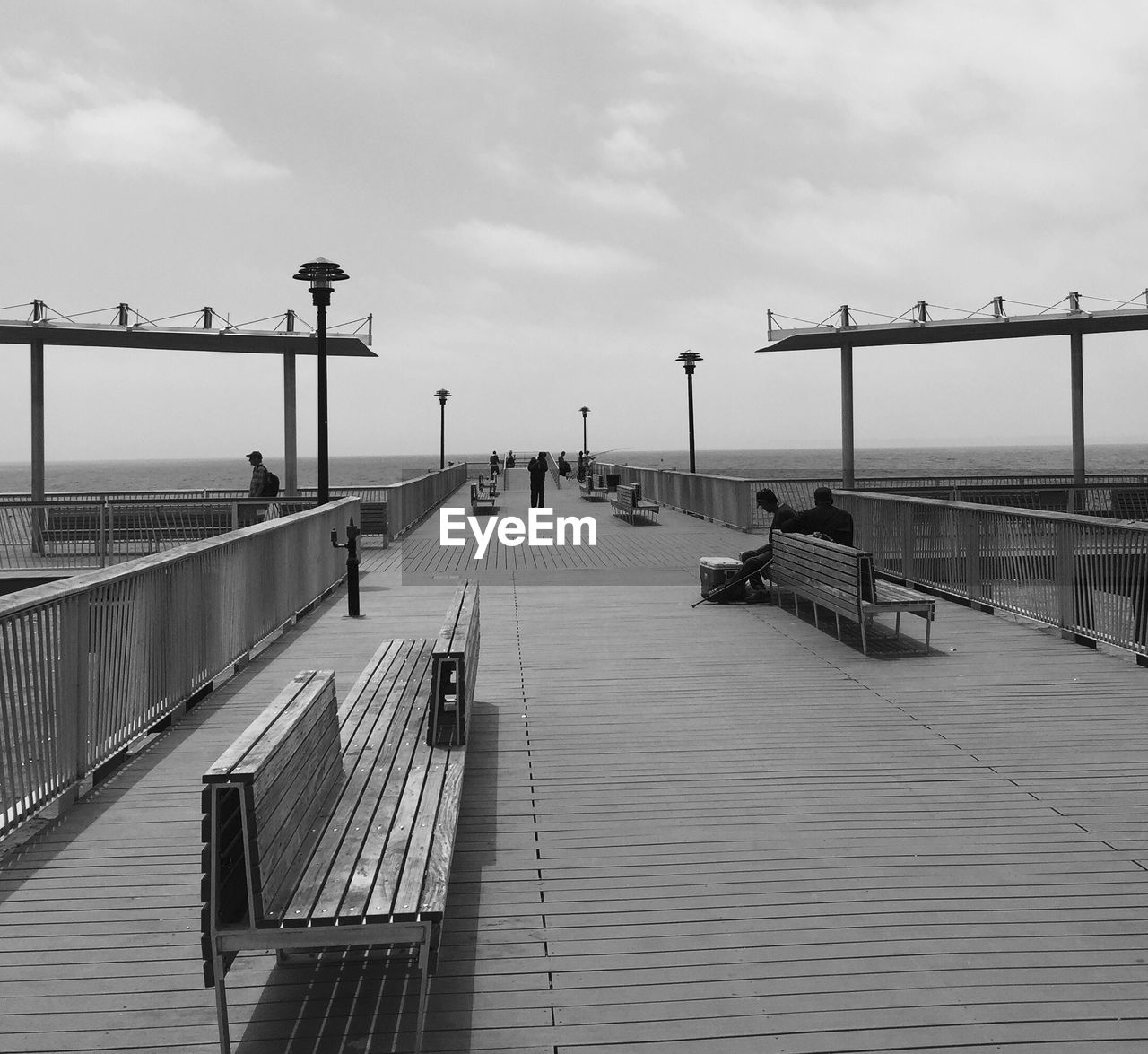 People on boardwalk against sky