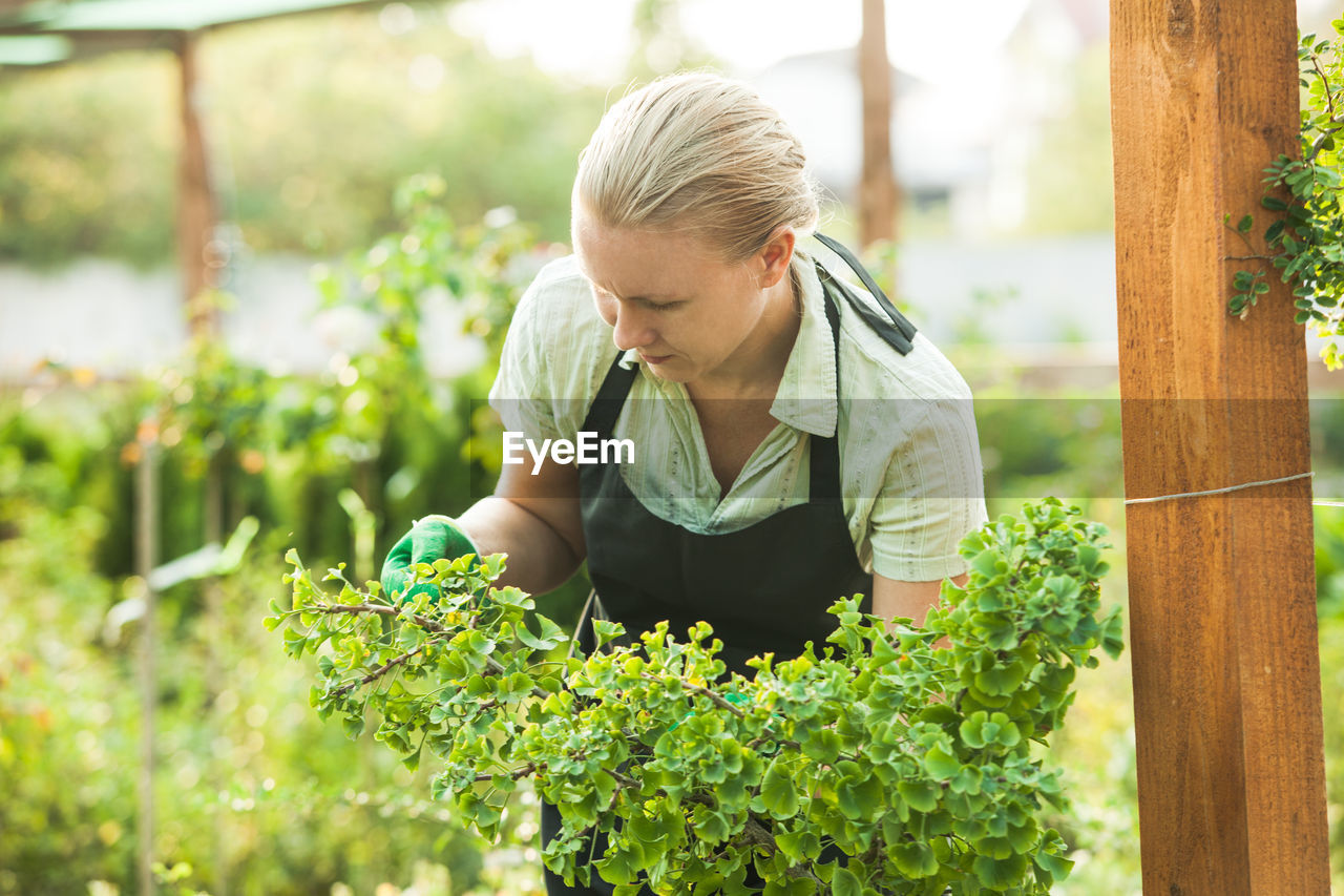 WOMAN HOLDING PLANTS