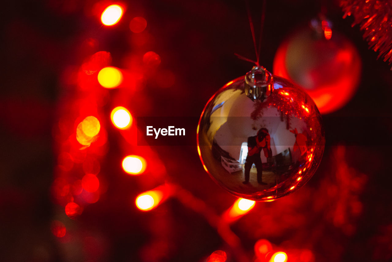 CLOSE-UP OF ILLUMINATED CHRISTMAS DECORATIONS ON TREE