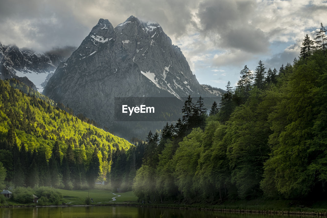 Scenic view of lake by trees against sky