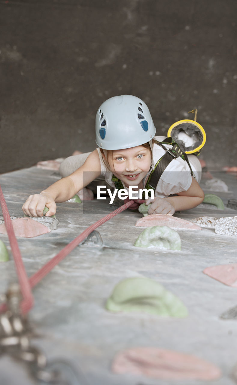 Young girl climbing at indoor climbing wall in england / uk