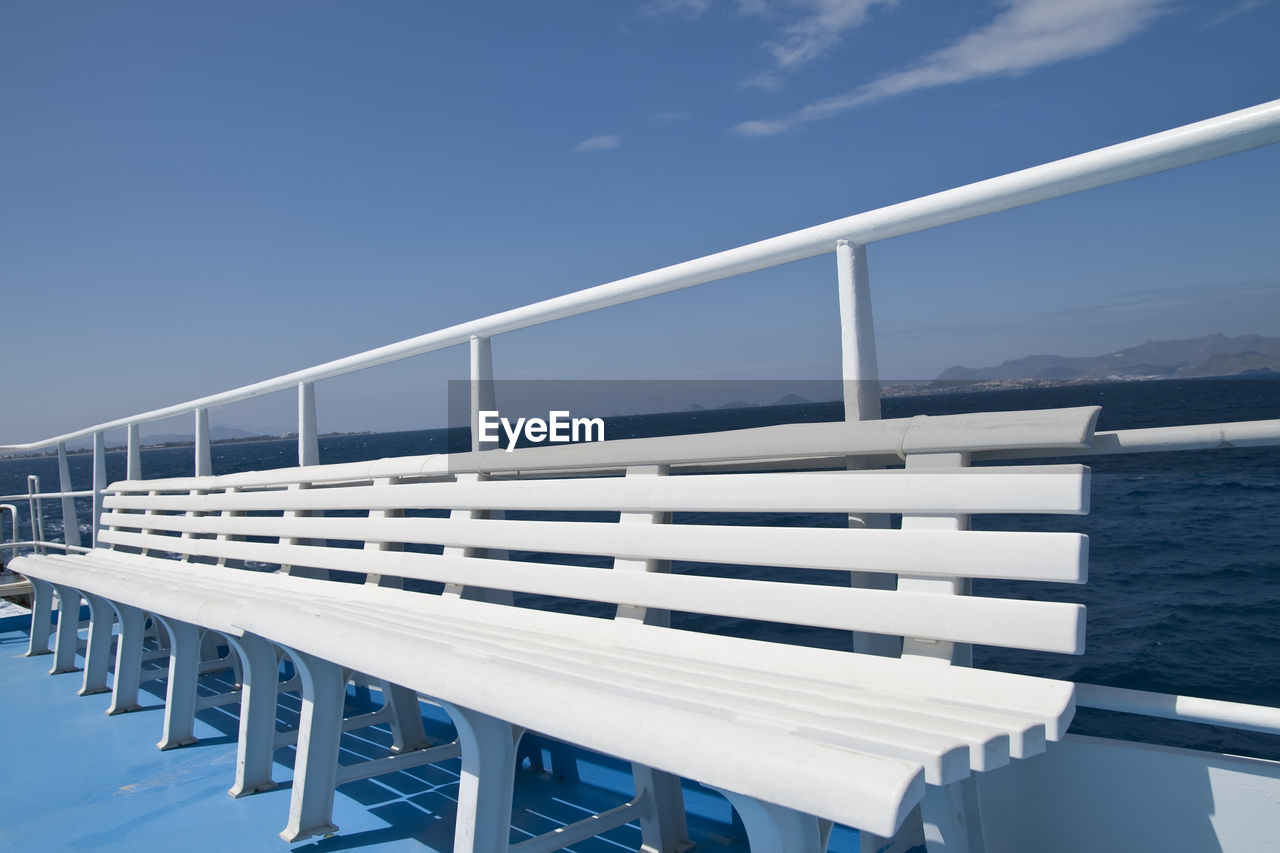 Railing by sea against sky