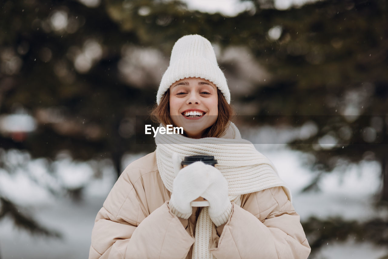 young woman standing against trees during winter