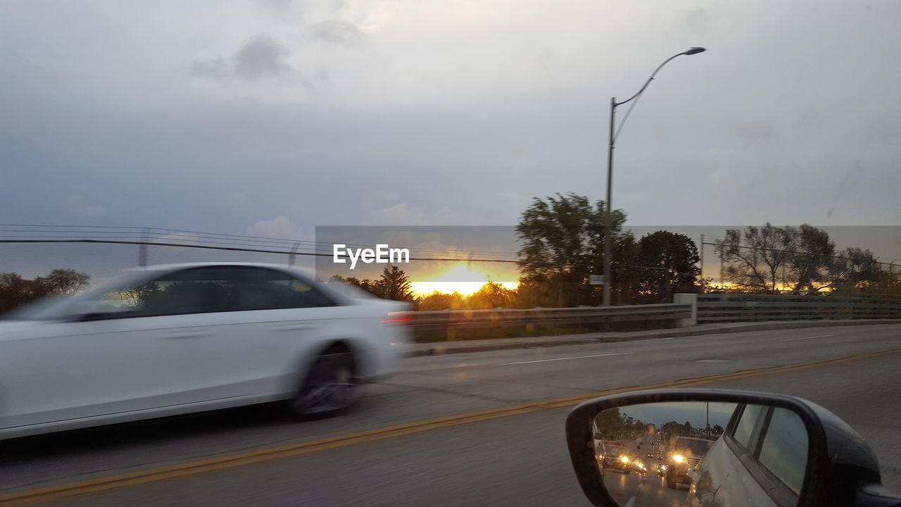 CAR ON ROAD AGAINST SKY