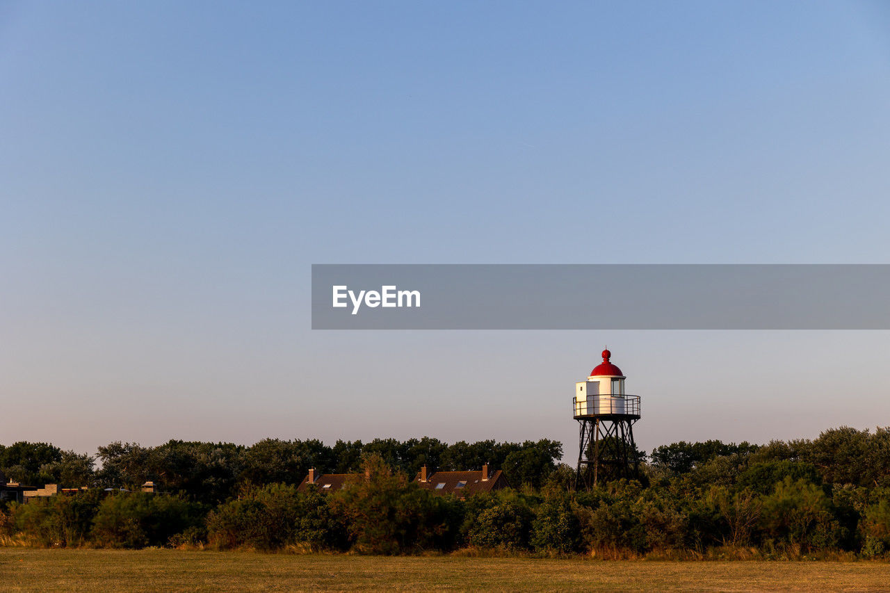 A beautiful white and red lighthouse on the north sea coast in the netherlands.