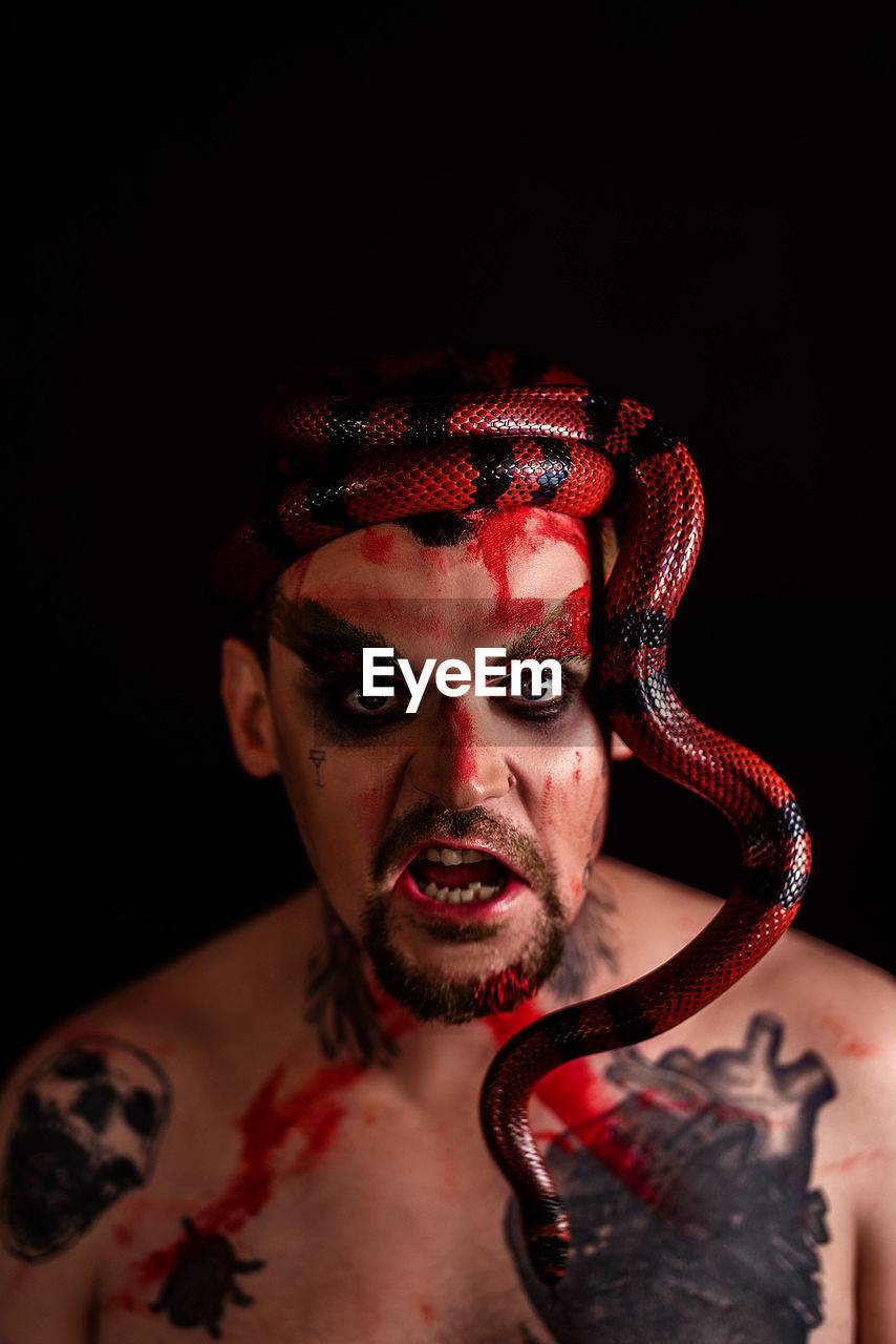 Male portrait with a snake on a black background