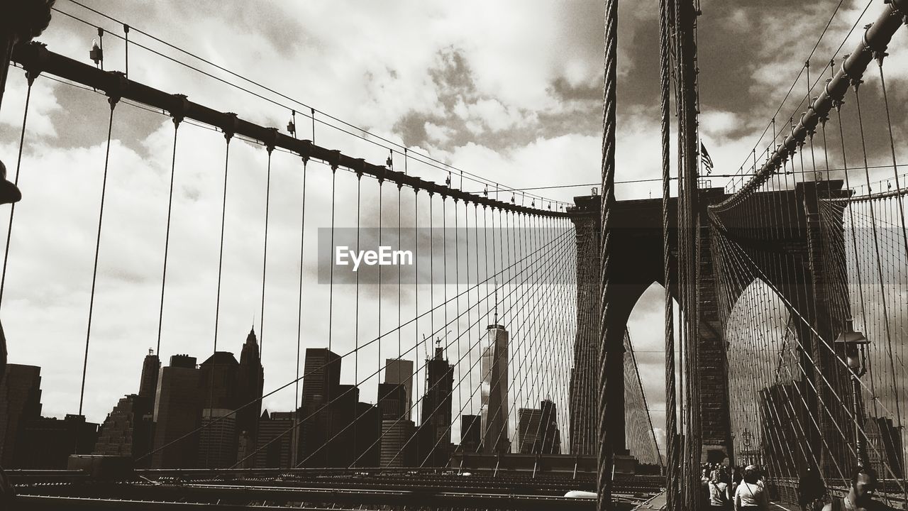 Low angle view of brooklyn bridge against cloudy sky