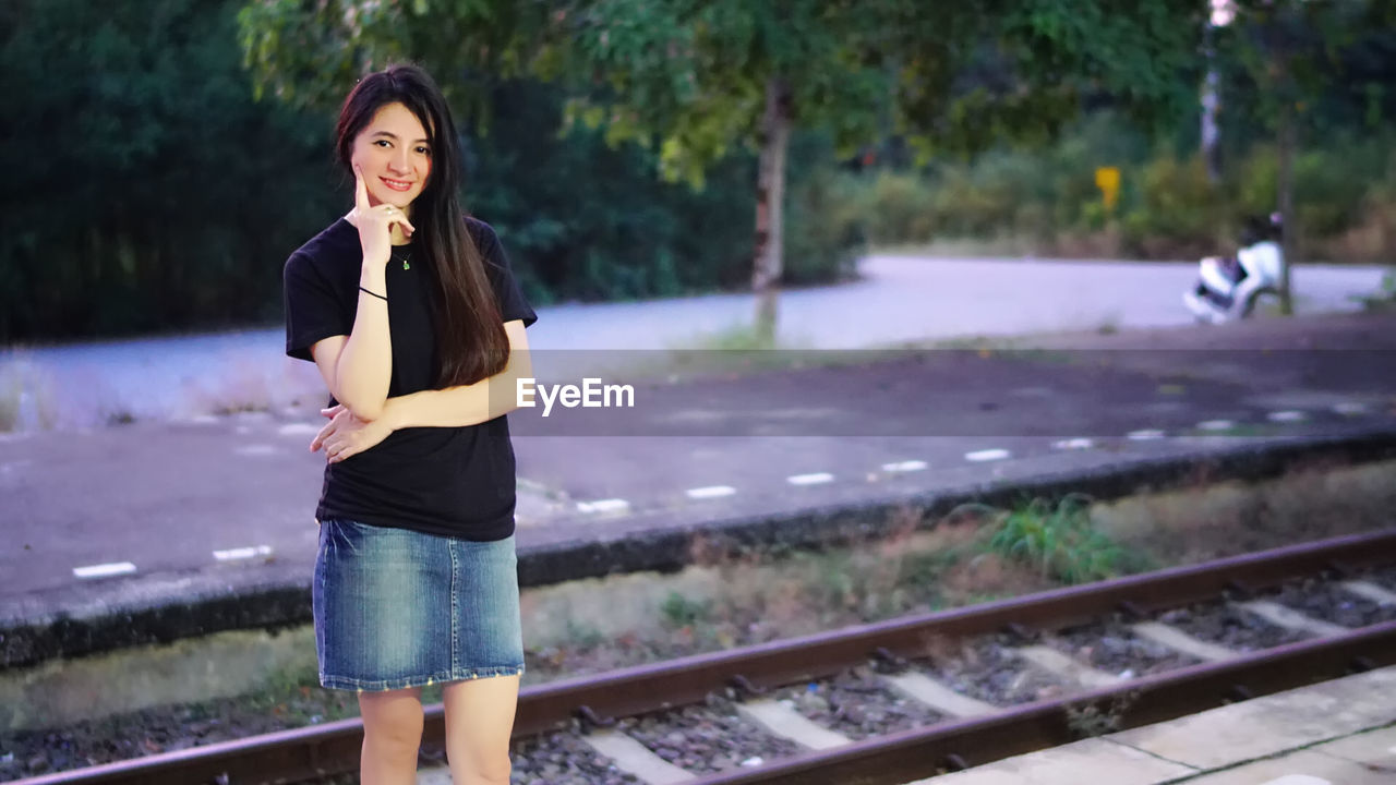 Portrait of mature woman standing at railroad