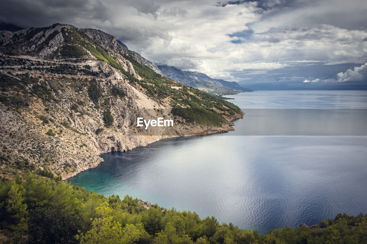 High angle view of river amidst mountains against sky