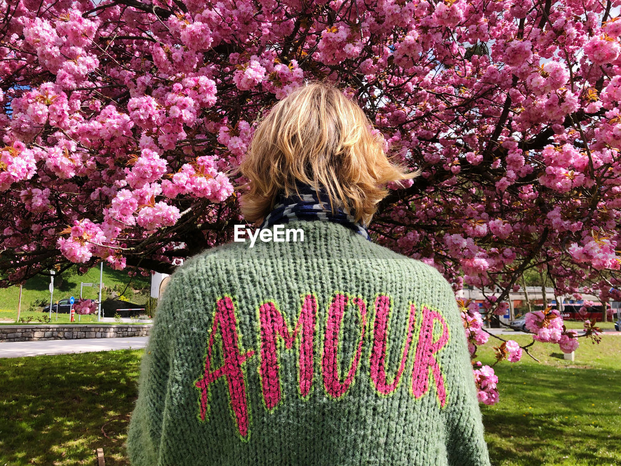 rear view of woman standing amidst plants on field