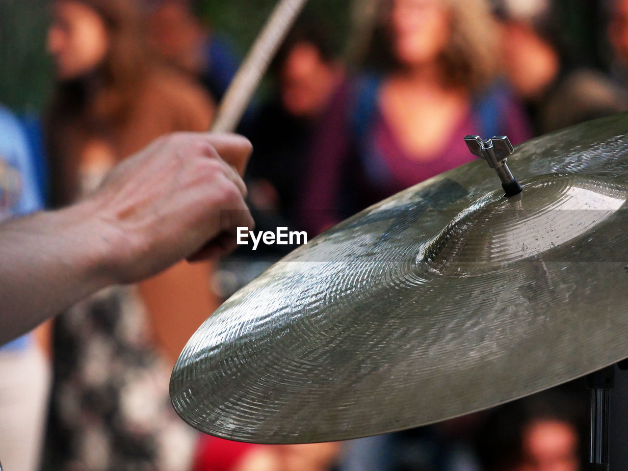 Cropped hand playing cymbal during event in city