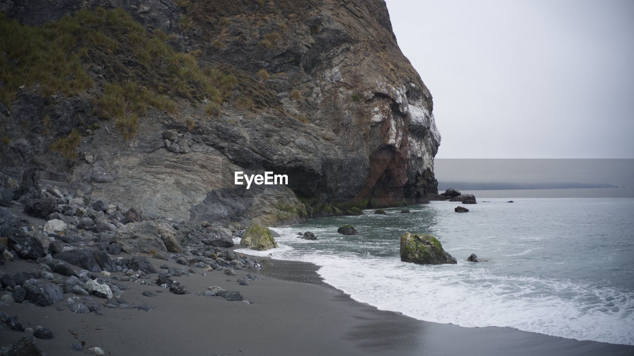 SCENIC VIEW OF ROCKS ON SEA AGAINST SKY