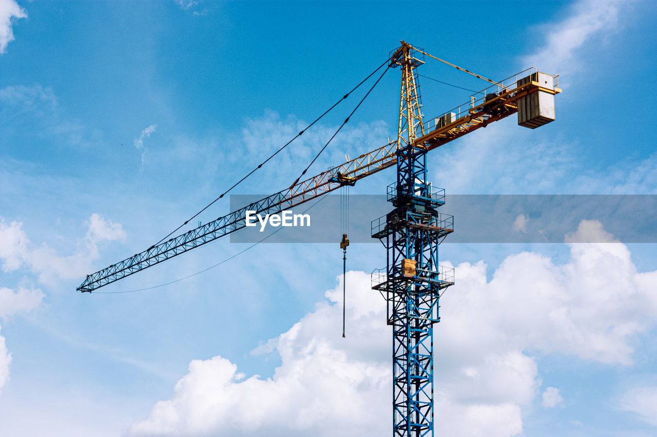 LOW ANGLE VIEW OF CRANE AT CONSTRUCTION SITE AGAINST SKY