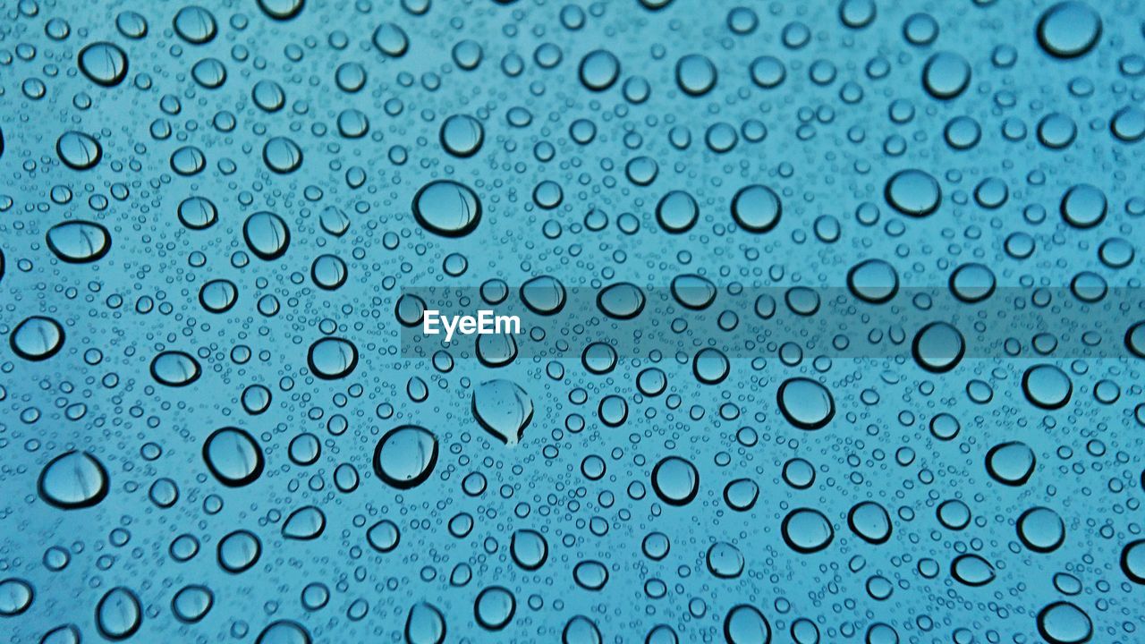 FULL FRAME SHOT OF WATER DROPS ON GLASS