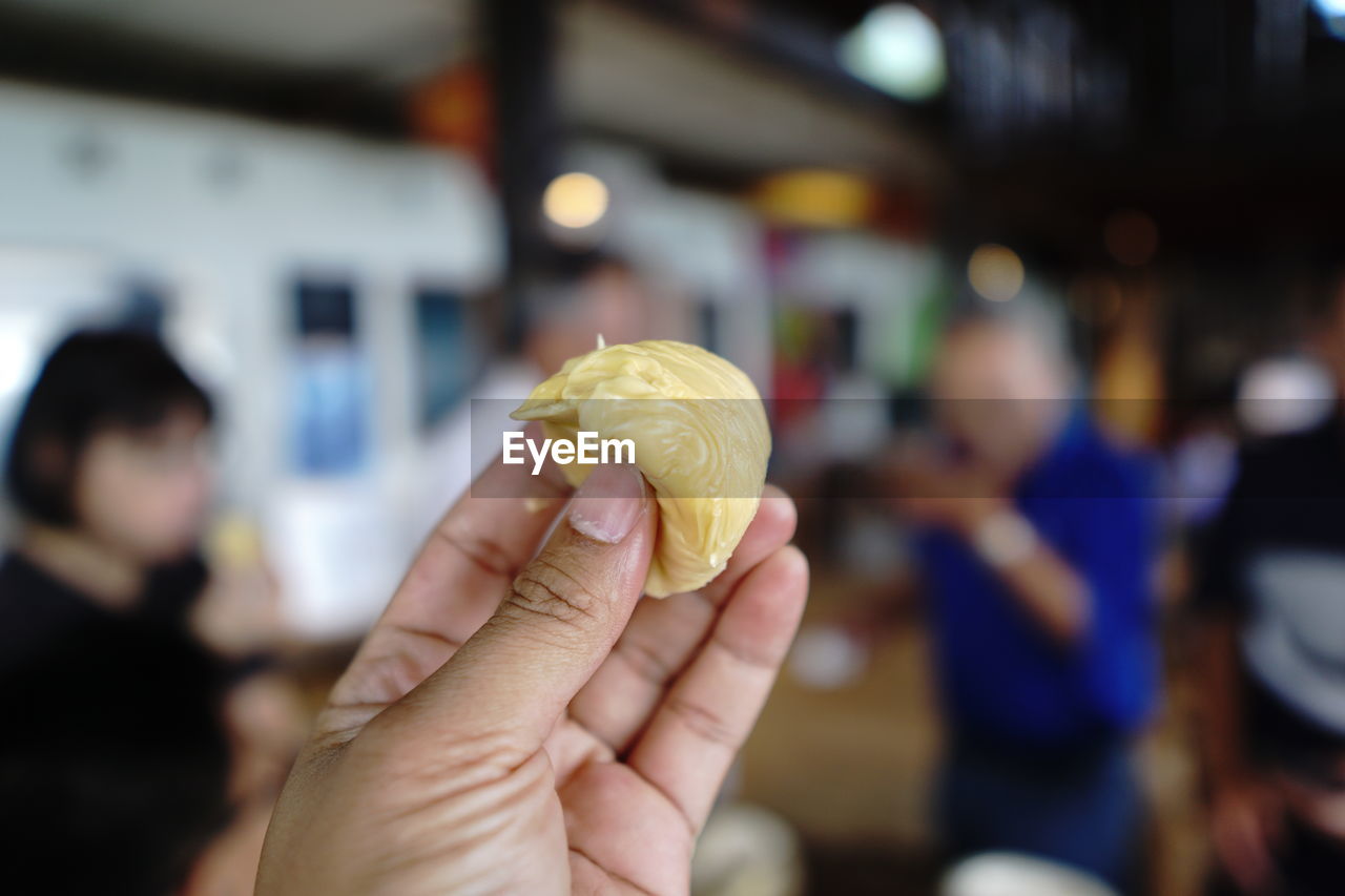 Yellow durian fruit on your fingers