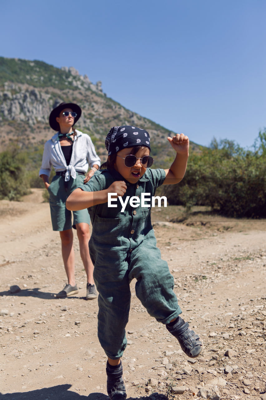 Child boy walks with his mother in the mountains in the summer