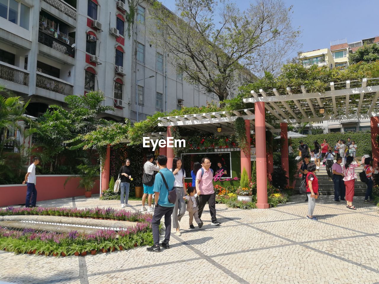 PEOPLE ON SIDEWALK AGAINST BUILDINGS