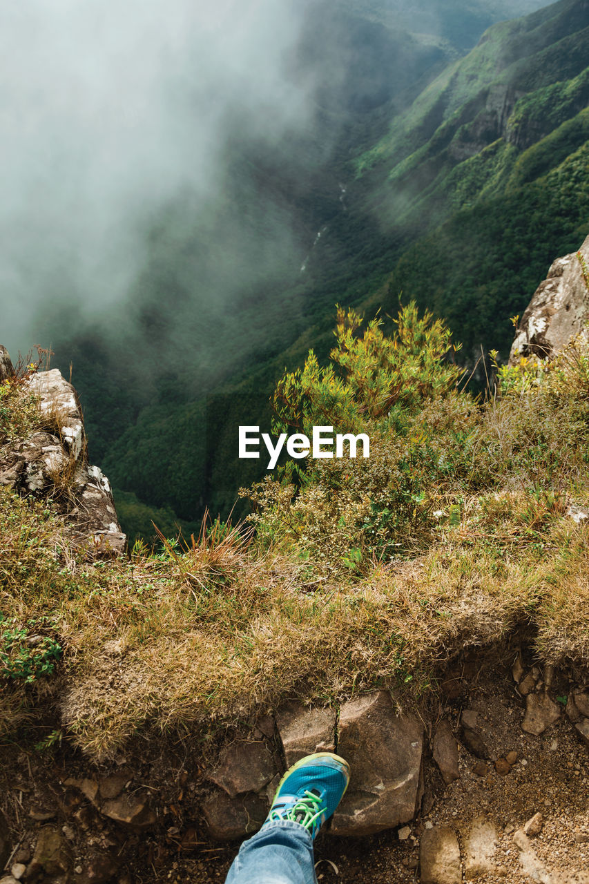 Low section of person standing on mountain