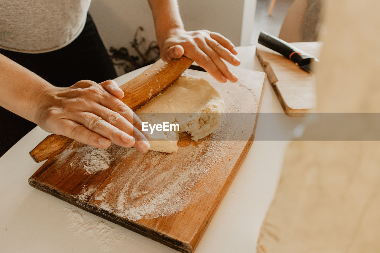 Midsection of woman rolling dough