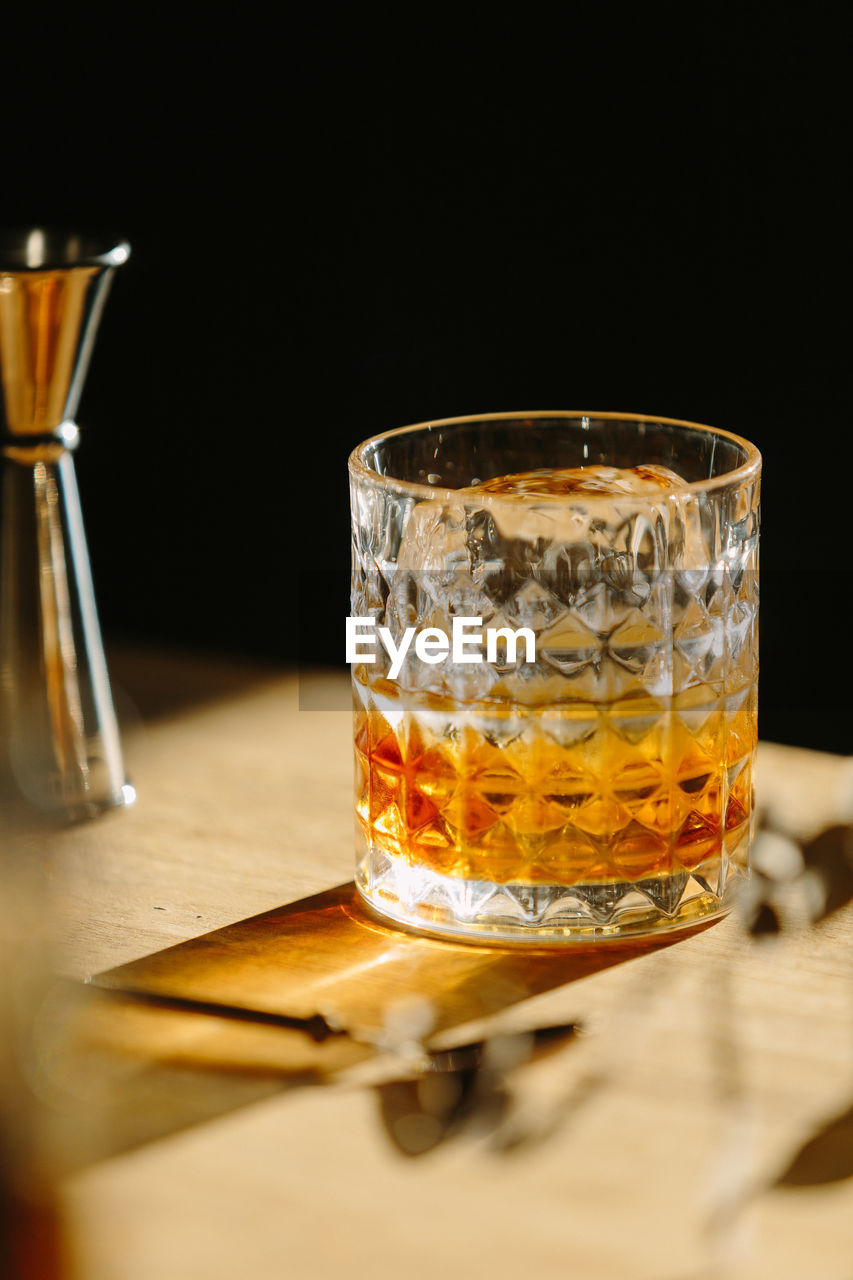 Close-up of glass with bourbon whiskey on table