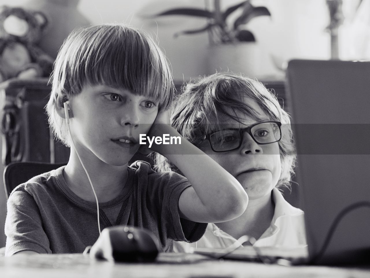 Boys looking at laptop on table