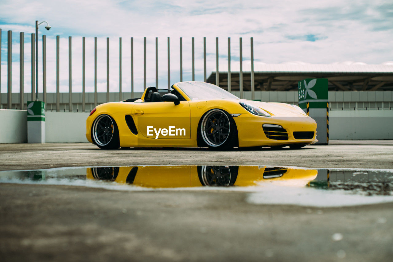 car, land vehicle, vehicle, mode of transportation, transportation, motor vehicle, yellow, sports car, automobile, yellow taxi, supercar, cloud, architecture, taxi, performance car, sky, wheel, day, no people, road, outdoors, luxury vehicle, city, water, nature