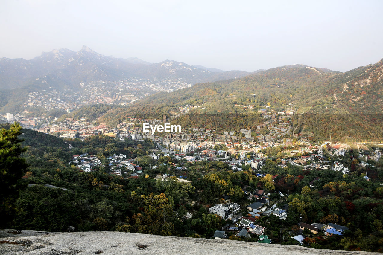 High angle view of cityscape and mountains against sky