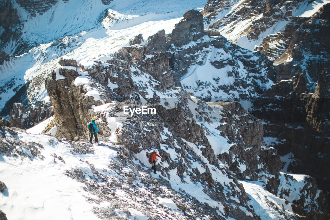 High angle view of friends hiking on snowcapped mountain