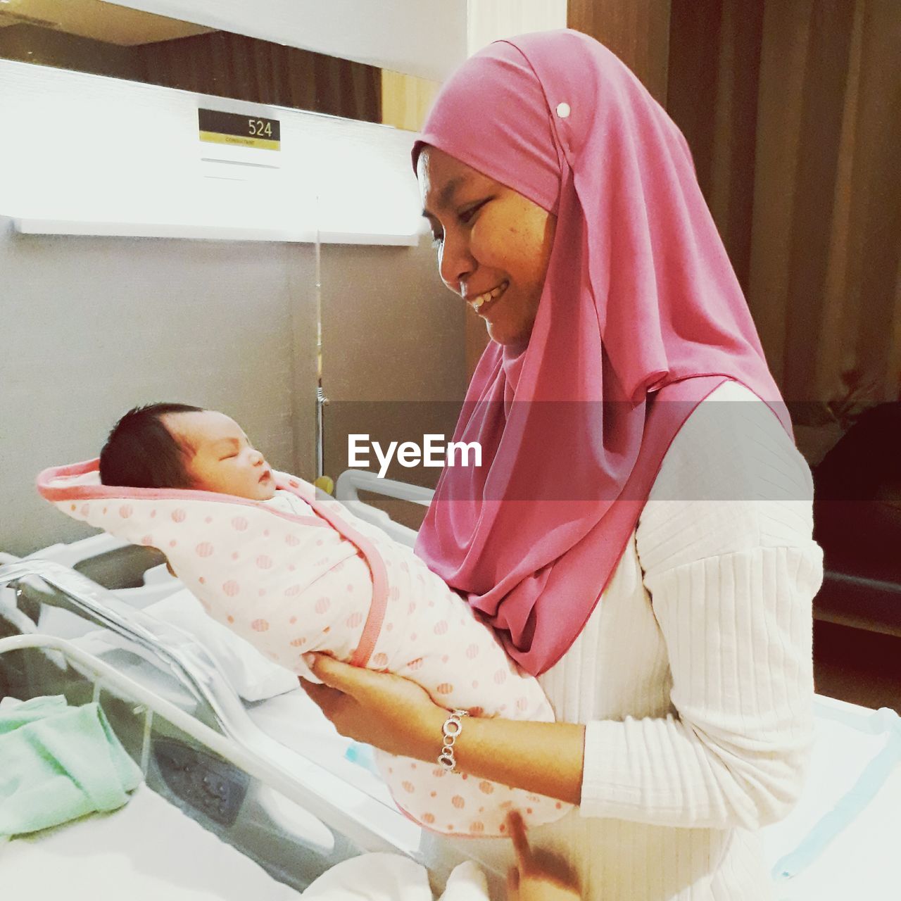 Smiling mother holding daughter at hospital