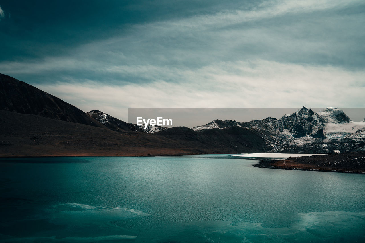 Scenic view of frozen lake and mountains 