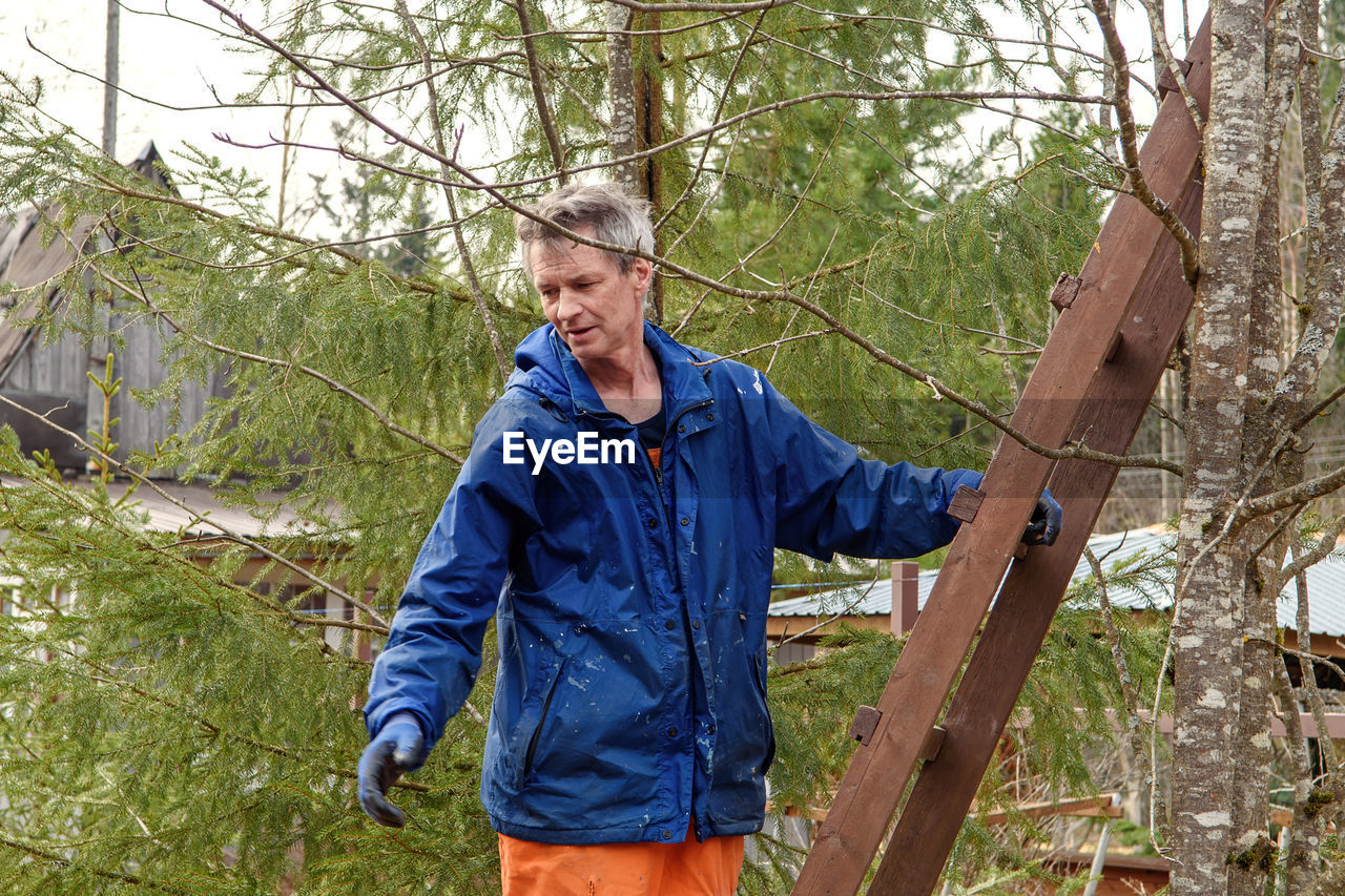 Man, tree surgeon prepares to climb the stairs