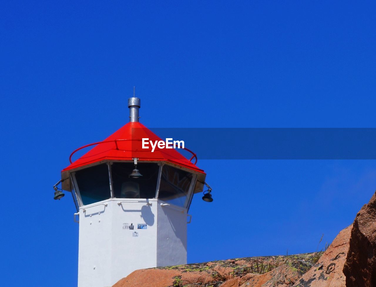 Low angle view of lighthouse against clear blue sky