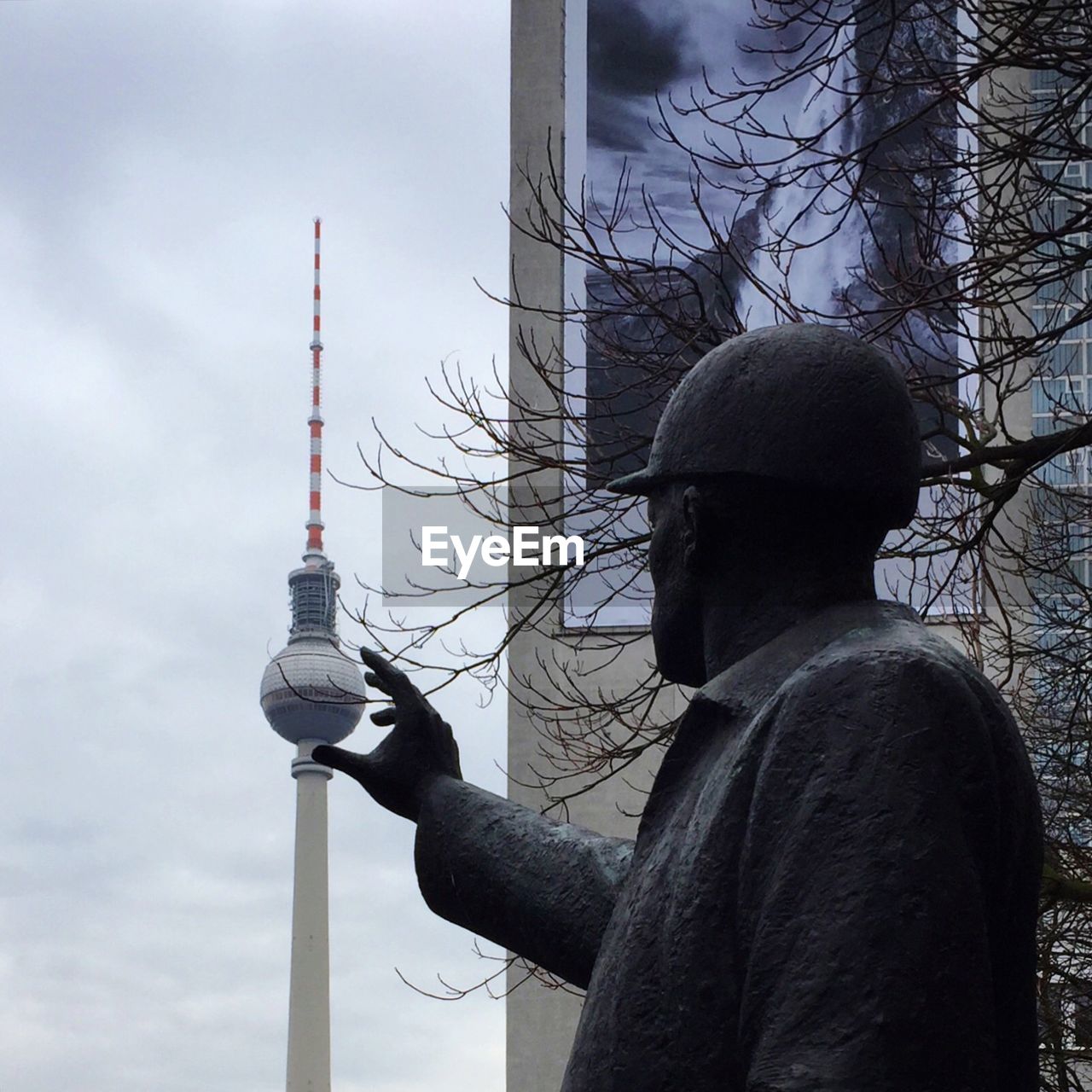 Optical illusion of statue touching sphere of fernsehturm