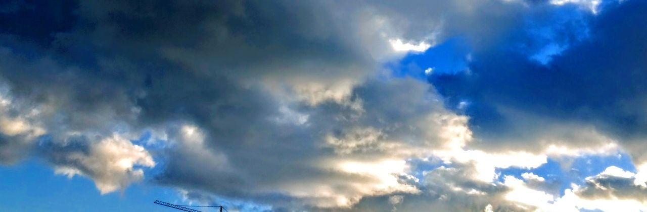 LOW ANGLE VIEW OF CLOUDS IN BLUE SKY AND SUNLIGHT