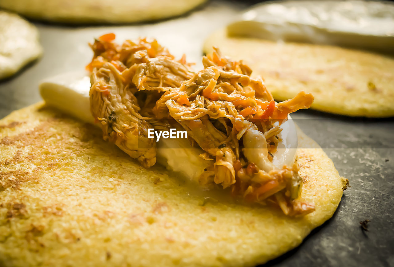 Close-up of chicken and cheese on corn bread at market stall