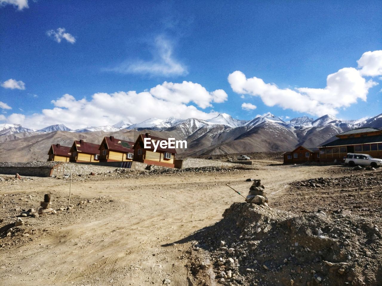 HOUSES ON SNOW COVERED LAND AGAINST SKY