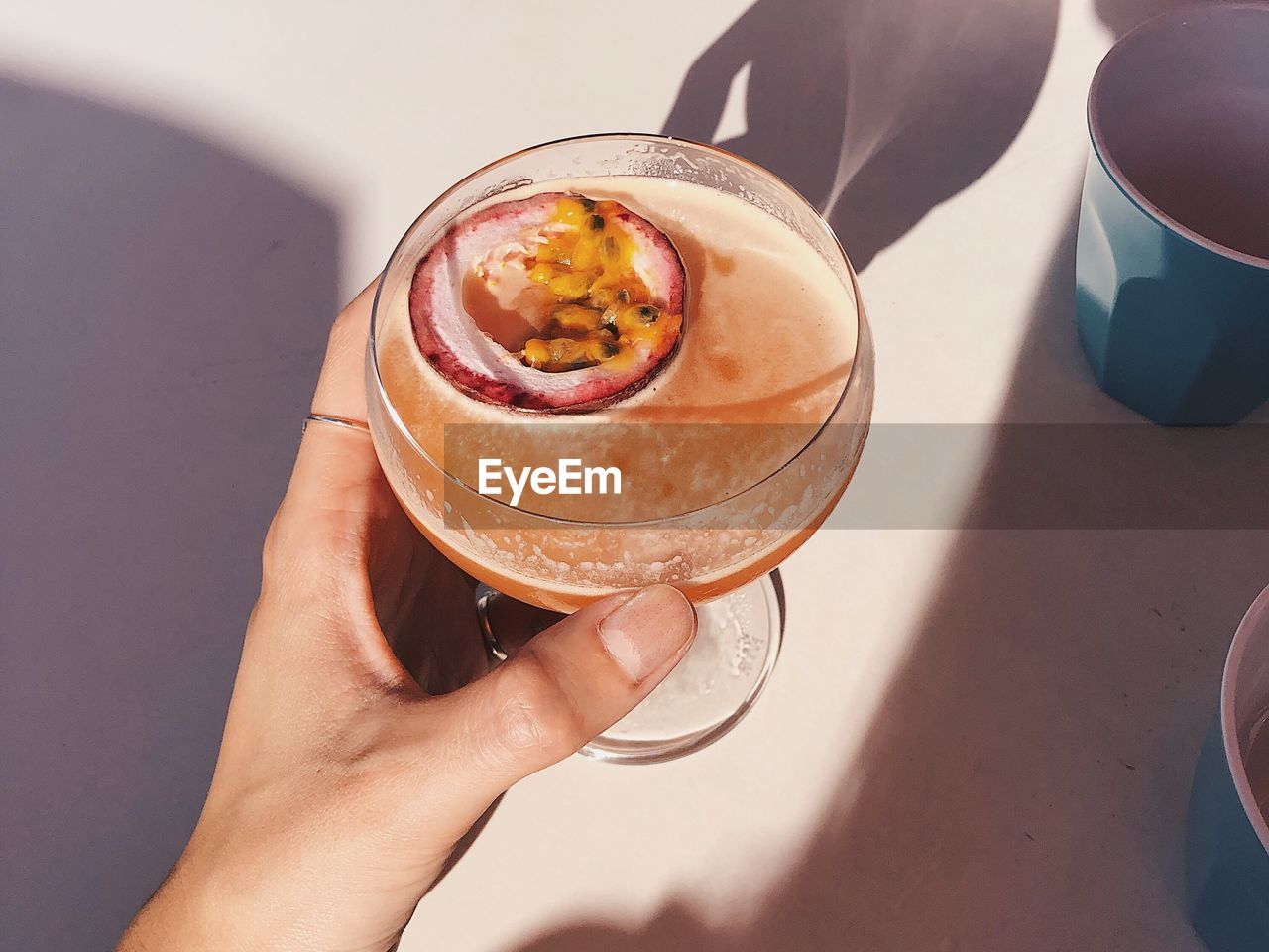 Close-up of cropped hand holding drink glass at table