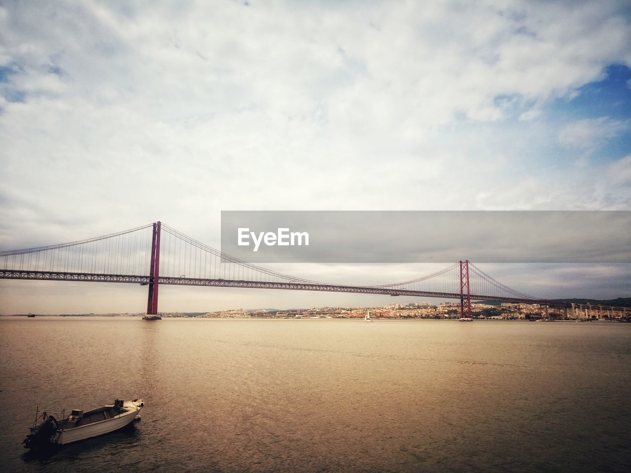 View of suspension bridge against cloudy sky