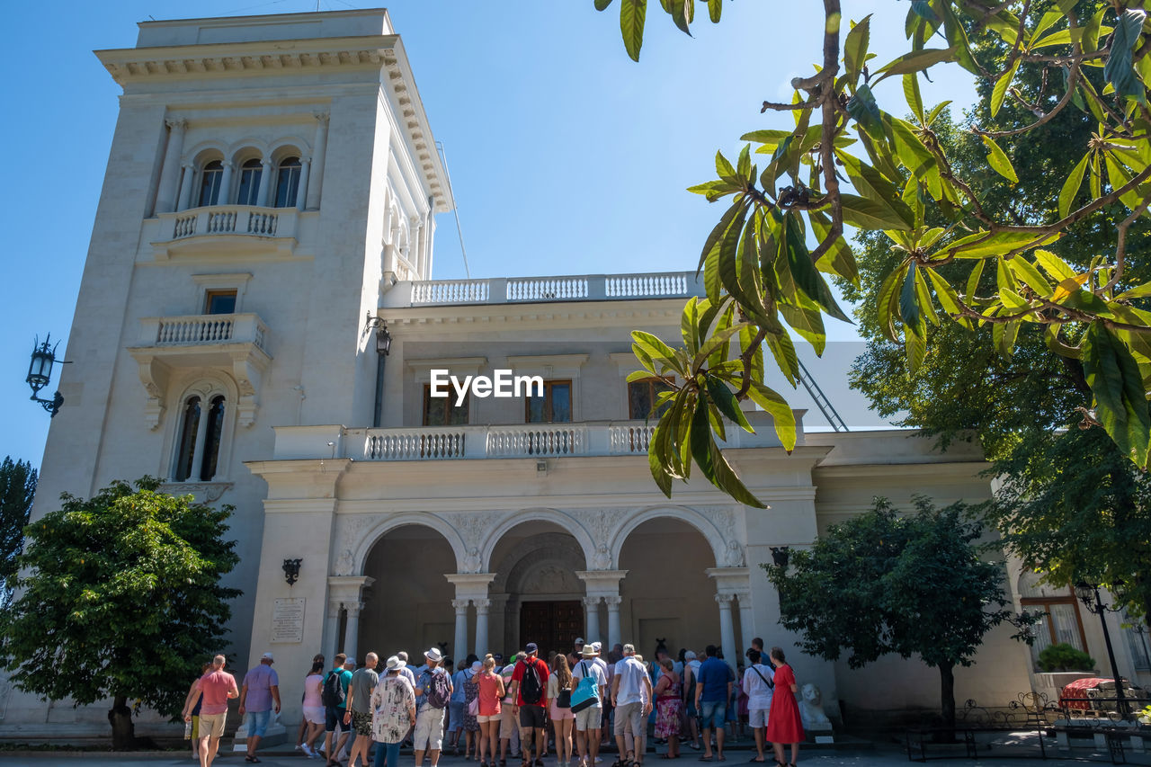 GROUP OF PEOPLE OUTSIDE BUILDING