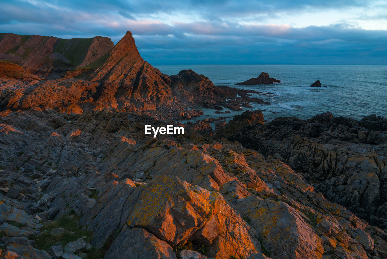 Scenic view of rock formation by sea against sky