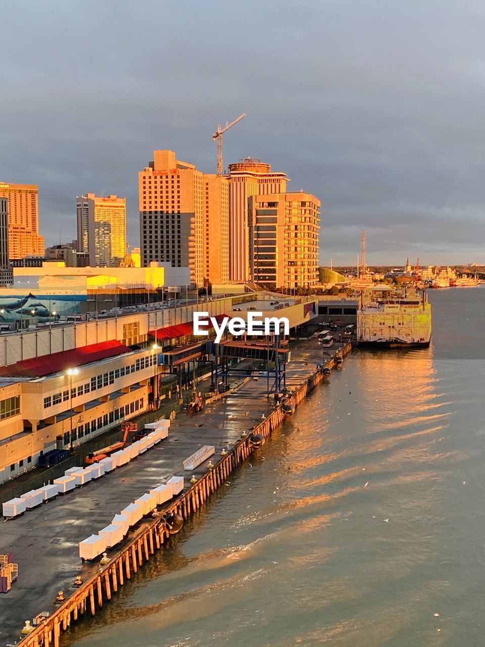 Buildings by river against sky in city