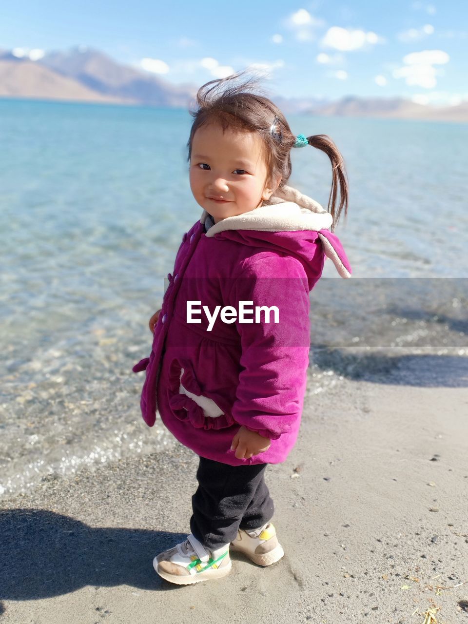 Portrait of girl standing at lakeshore