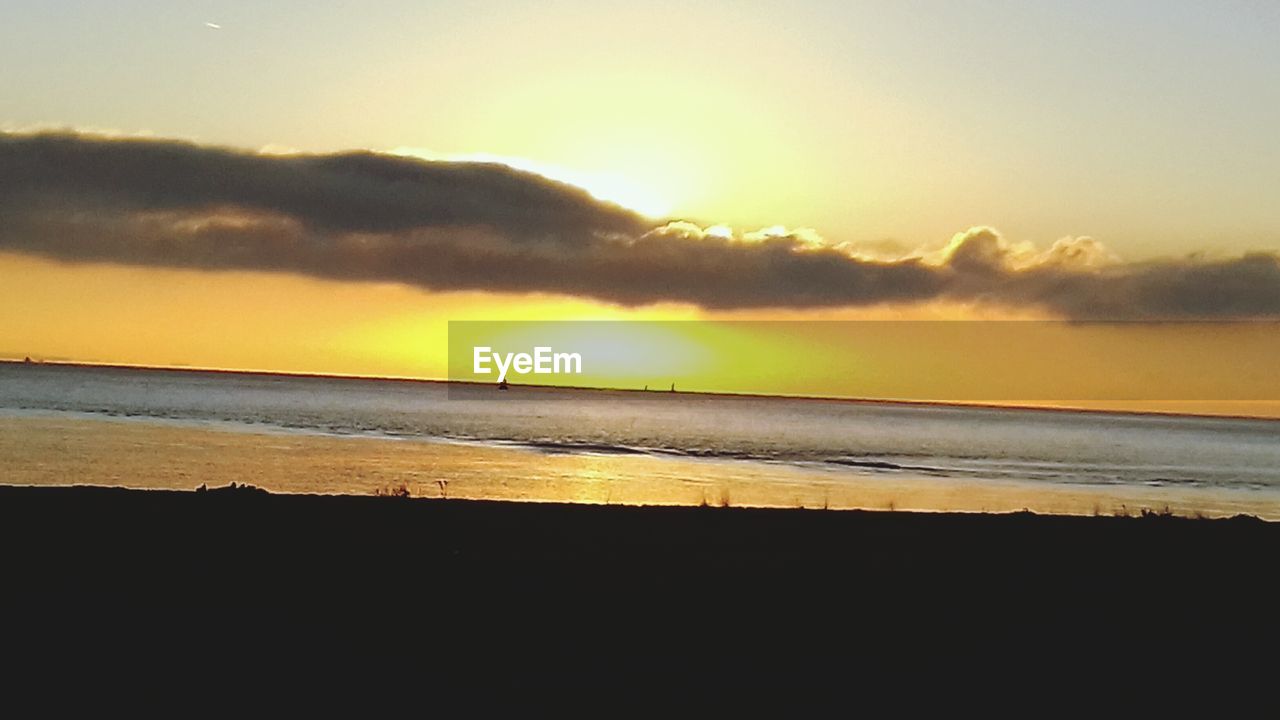 SCENIC VIEW OF BEACH AGAINST SKY AT SUNSET