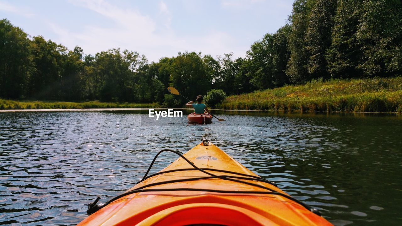 PERSON IN BOAT ON RIVER AGAINST SKY