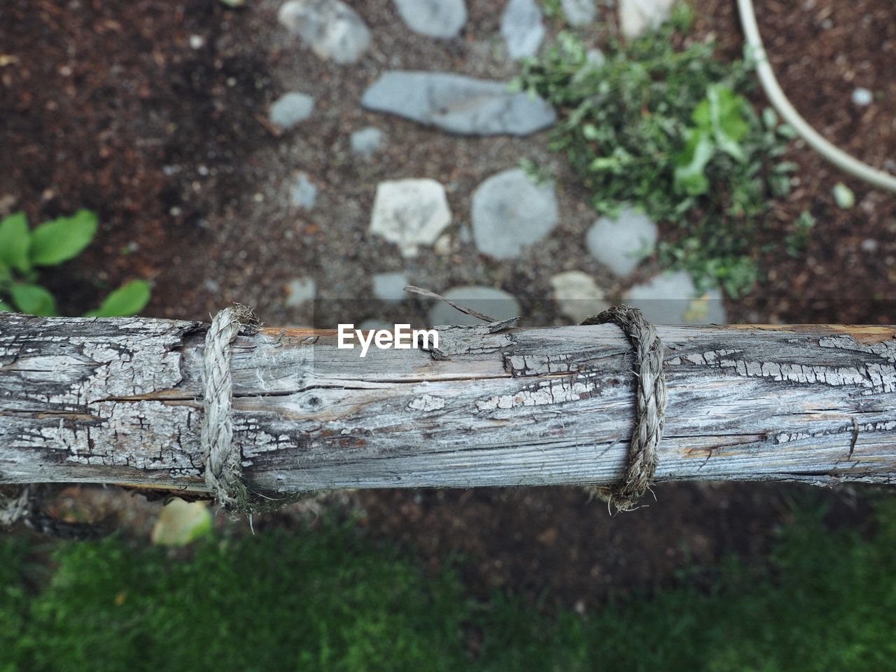 High angle view of rope on wood over footpath at park