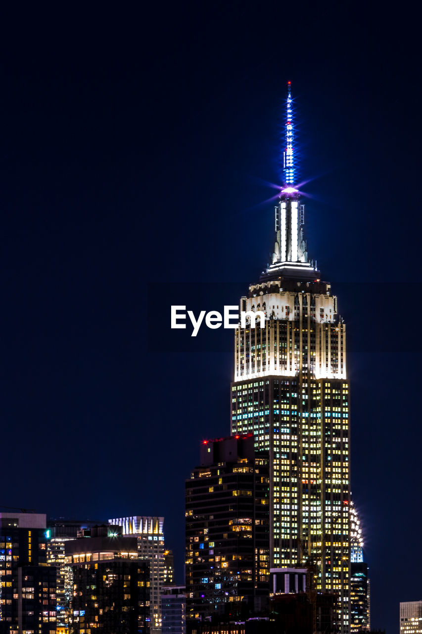 Low angle view of illuminated empire state building in city at night