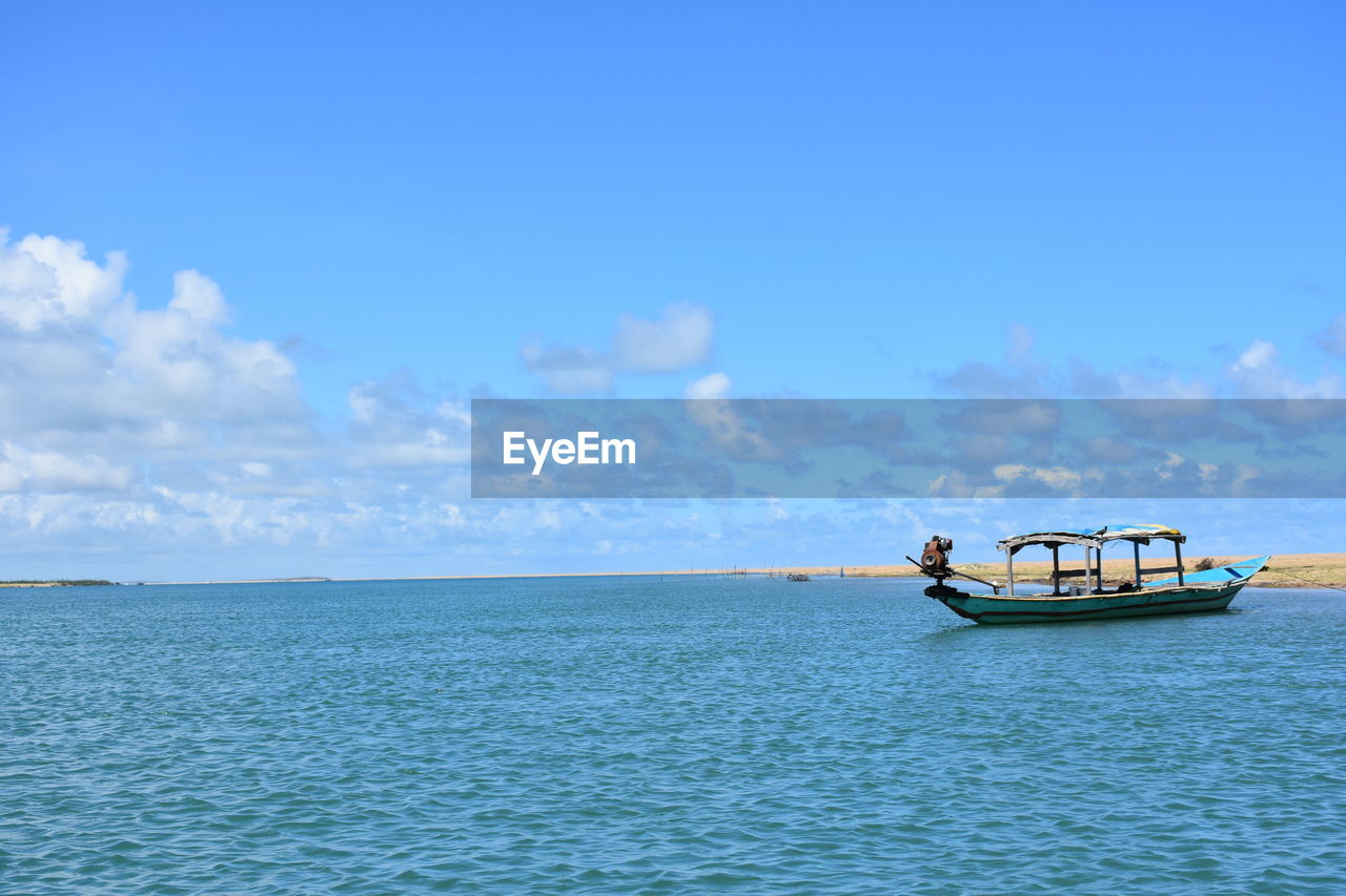 Boat on sea against blue sky